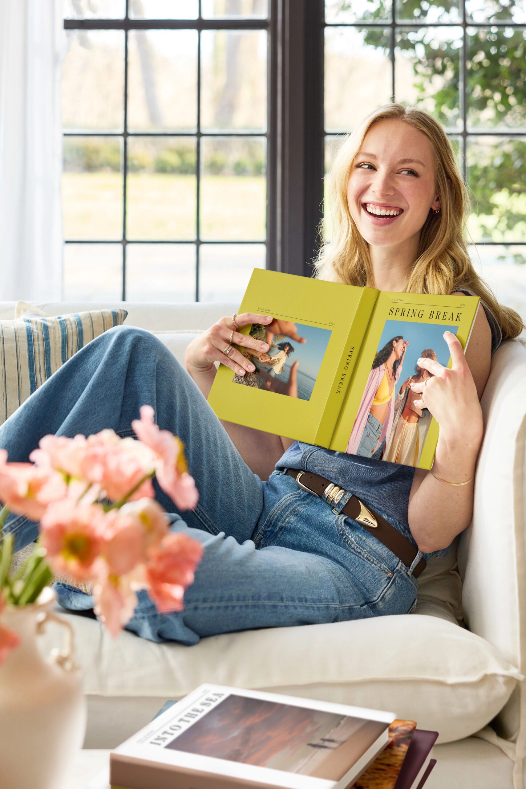 woman sitting on couch holding photo book
