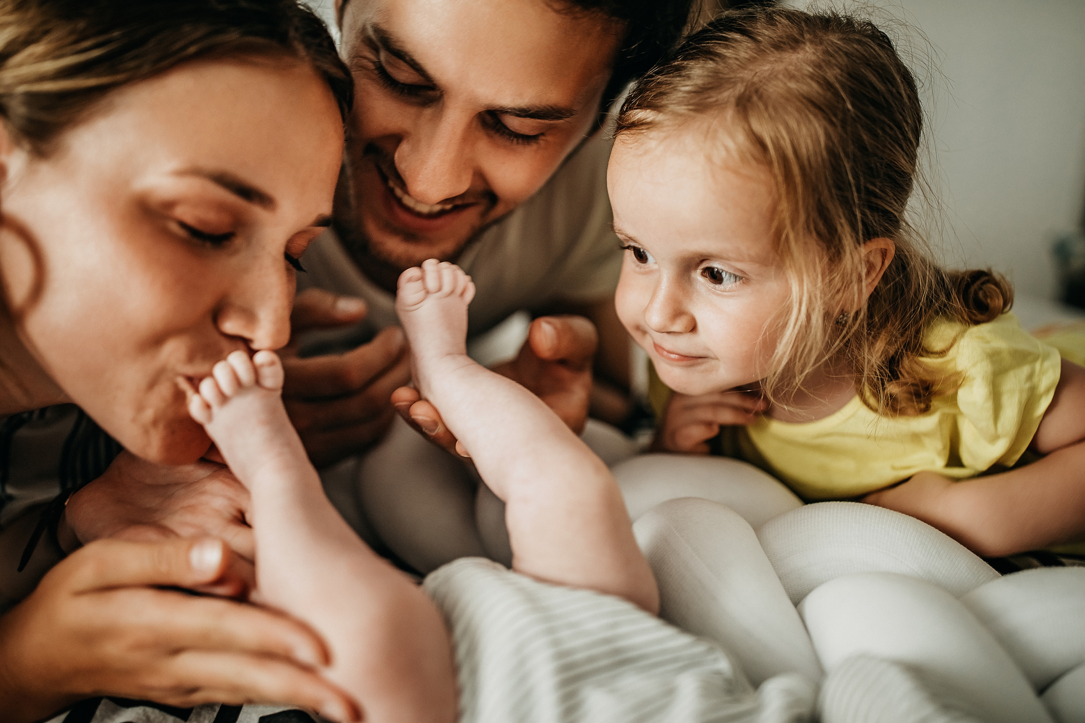 parents and daughter with new baby