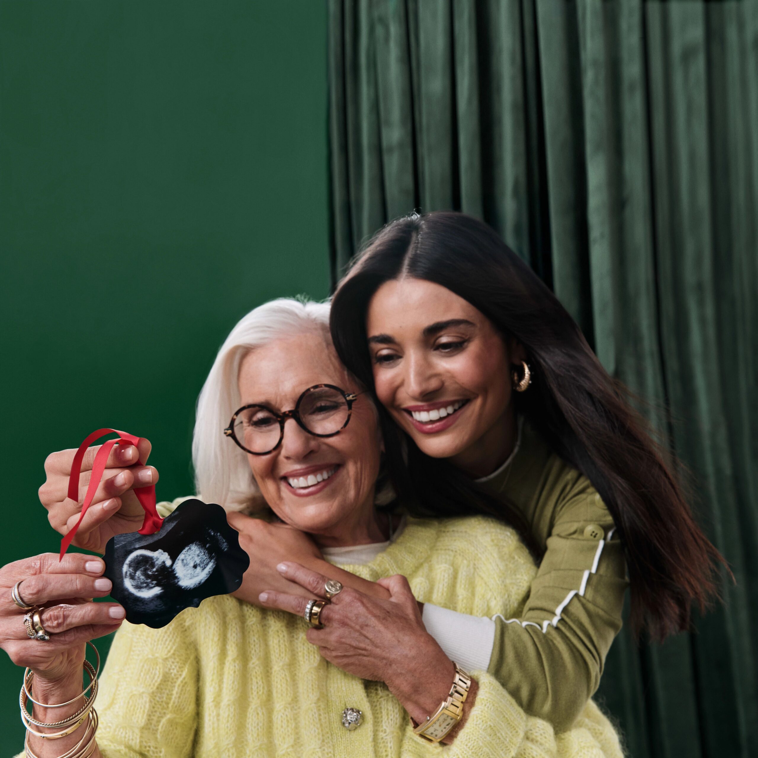 grandma and mom looking at photo ornament with ultrasound image